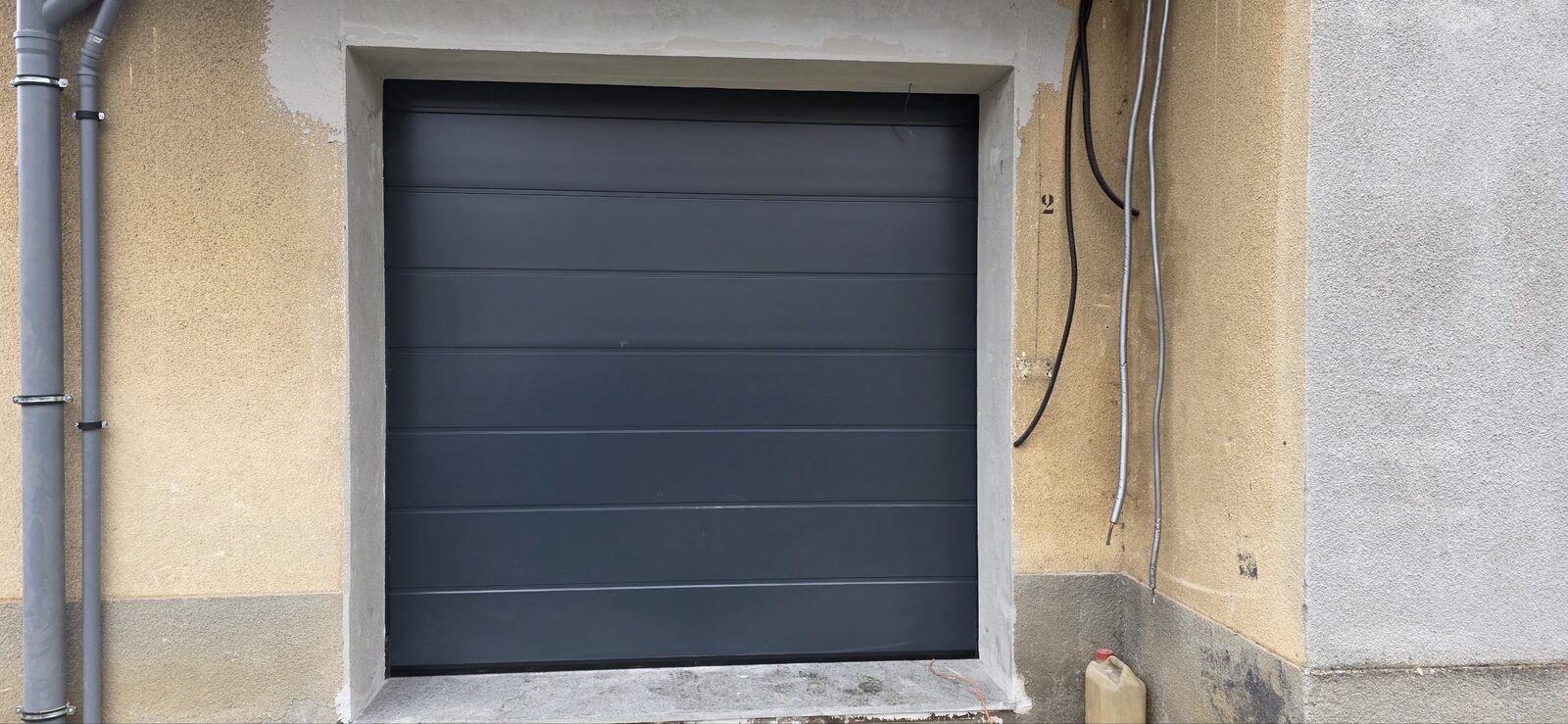 Porta da garage sezionale antracite con predisposizione elettrica, pronta per la motorizzazione