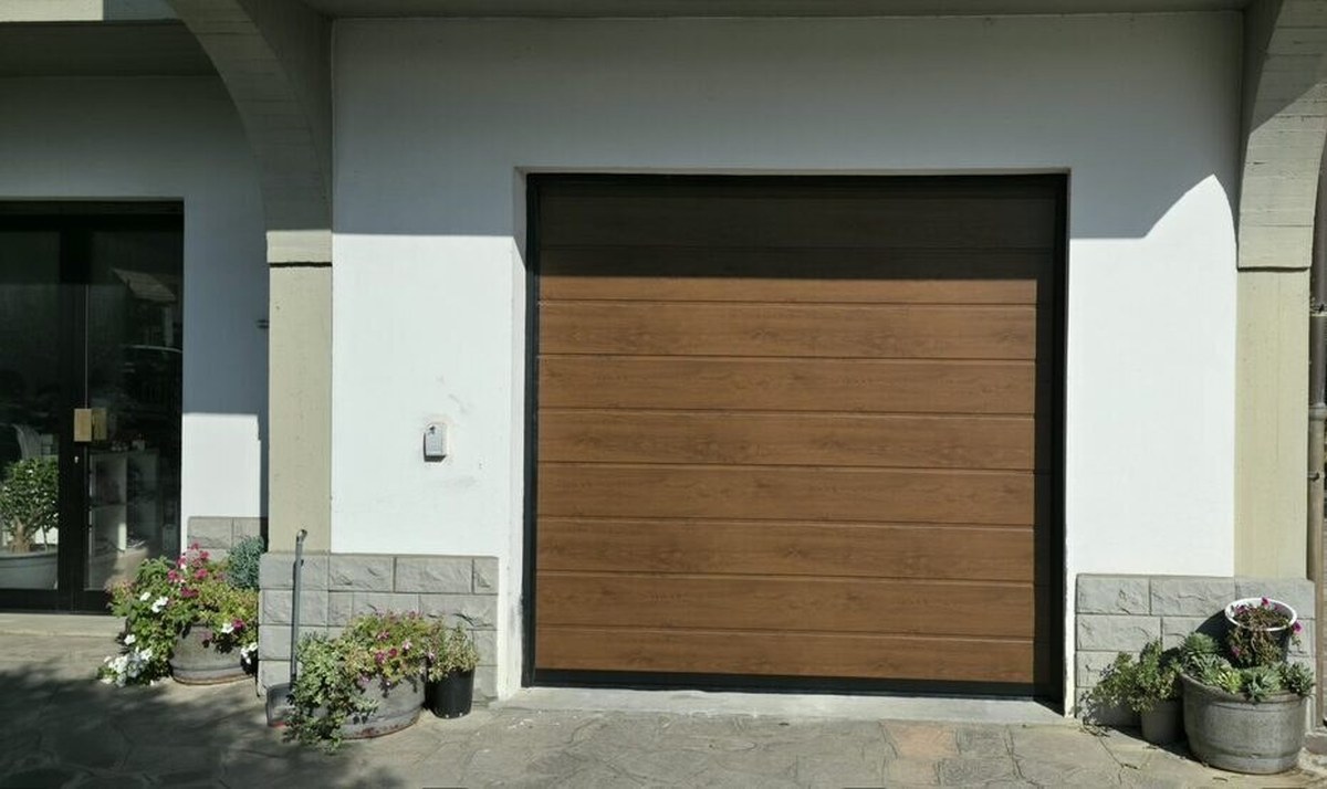 Porta da garage sezionale in finitura legno con telaio nero, esempio di porta esistente da motorizzare